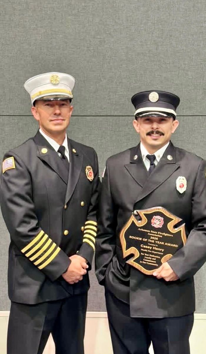 ASFFA 2026 Kevin McMaster’s Rookie of the Year Casey Henry Two firefighters in dress uniforms stand side by side. The firefighter on the right holds a large plaque that reads Rookie of the Year Award. Both are smiling and posing for the photo against a plain background.